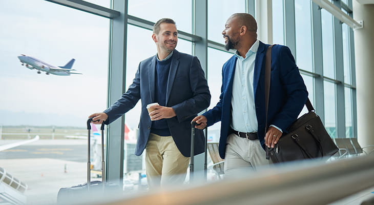 Two travelers walk through an airport