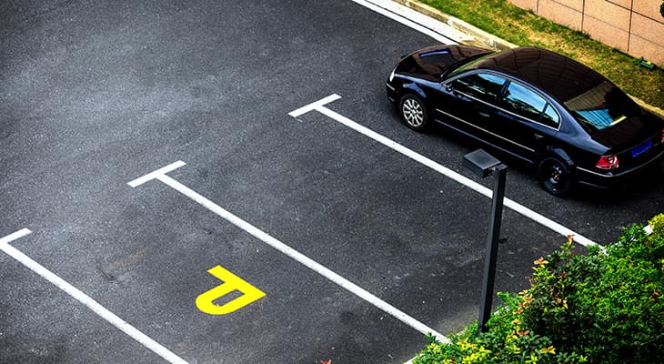 A near-empty parking lot with one car parked