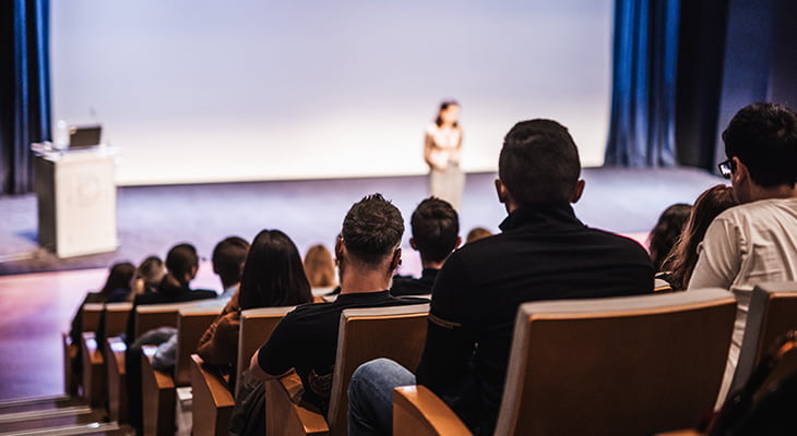 A keynote speaker at a conference addressing an audience.