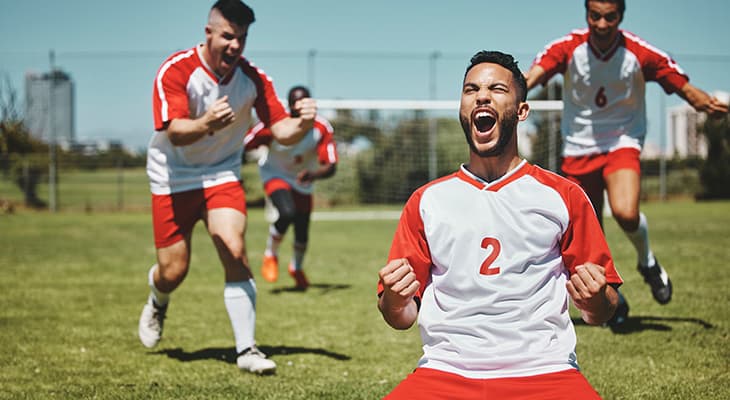 Soccer players celebrate a goal