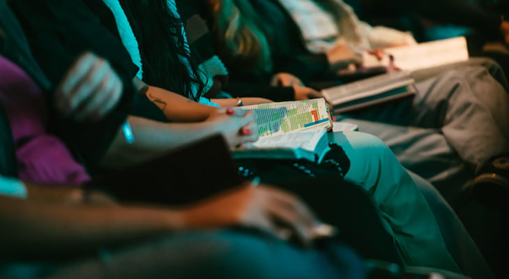 Conference attendees with bibles in their laps