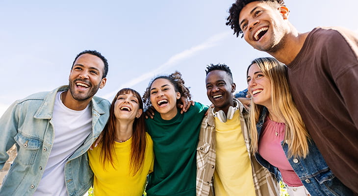 A group of young adults smile and embrace